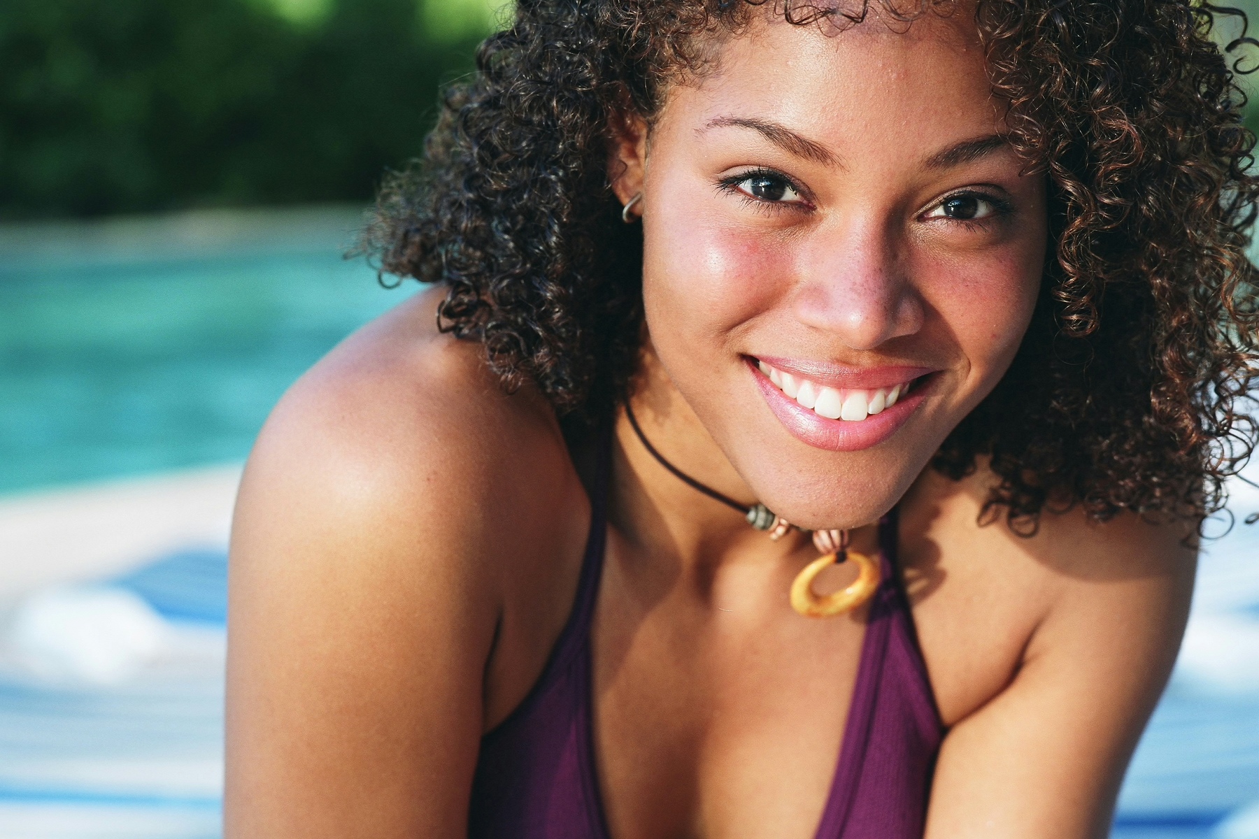 black girl smiling by swimming pool, dental crowns Honolulu, HI dentist